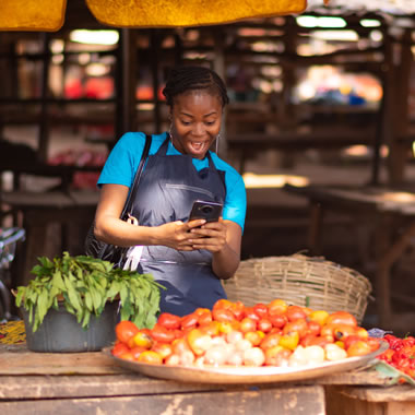 African market vendor using smartphone